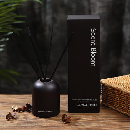 Black aroma diffuser with packaging labeled 'Scent Bloom' on a wooden surface.
