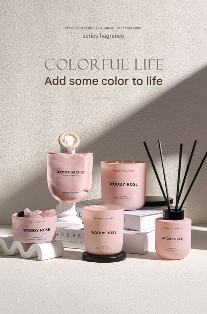 Pink candles and diffusers with 'Woody Rose' fragrance on a light background
