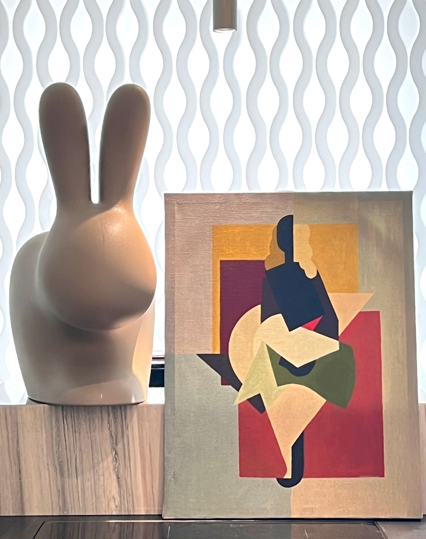 Decorative vase and abstract painting on a textured surface with wavy patterned wall in the background