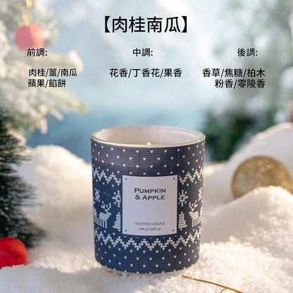 Candle with a blue patterned label on a snowy background