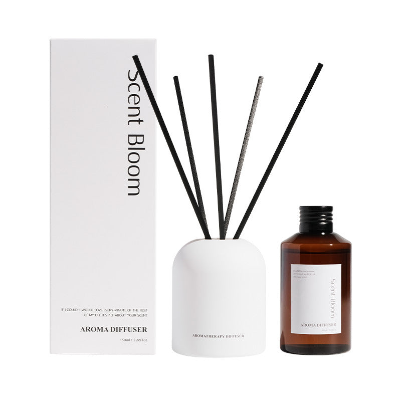 Aroma diffuser set with a bottle, white container, and black sticks on a white background.