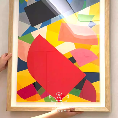 Colorful abstract art piece with geometric shapes in a wooden frame held by a person.