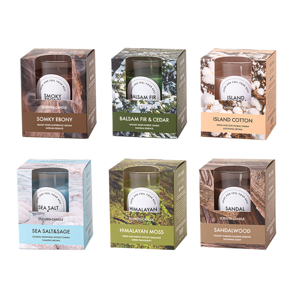 Set of six scented candles in their packaging with various fragrances on a white background.