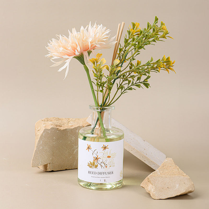 Reed diffuser with flowers and stones on a beige background