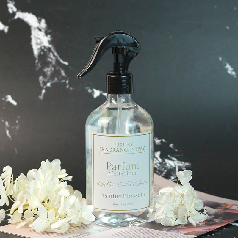 Luxury fragrance spray bottle labeled 'Parfum d'Intérieur Jasmine Blossom' with white flowers on a dark background