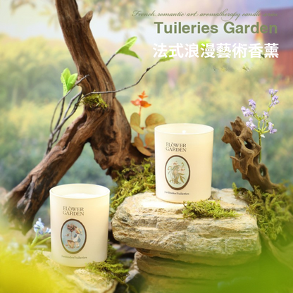 Two candles labeled 'Flower Garden' on a stone with natural elements and 'Tuileries Garden' branding.