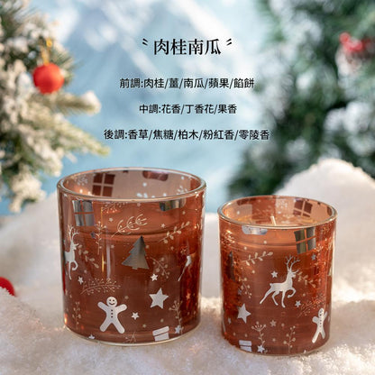 Two decorative glass candle holders with Christmas designs on a snowy background.