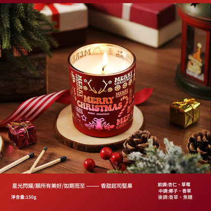 Decorative Christmas candle with festive design on a wooden surface with holiday decorations.