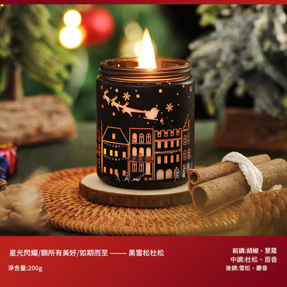 Candle in a decorative holder with Christmas-themed design on a woven surface.