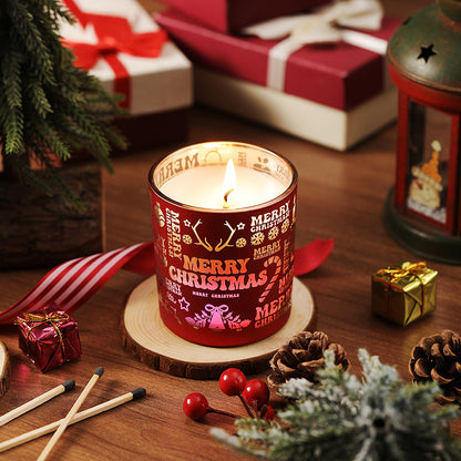 Red 'Merry Christmas' candle on a wooden coaster with holiday decorations.