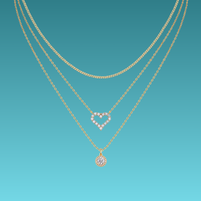Two gold necklaces with heart and round pendants on a teal background
