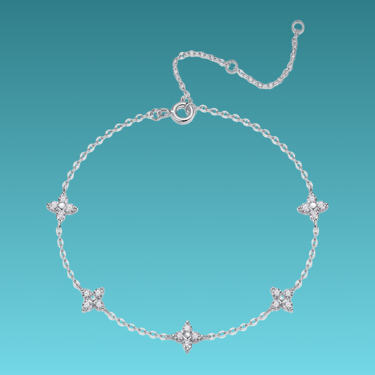 Silver bracelet with floral designs on a teal background