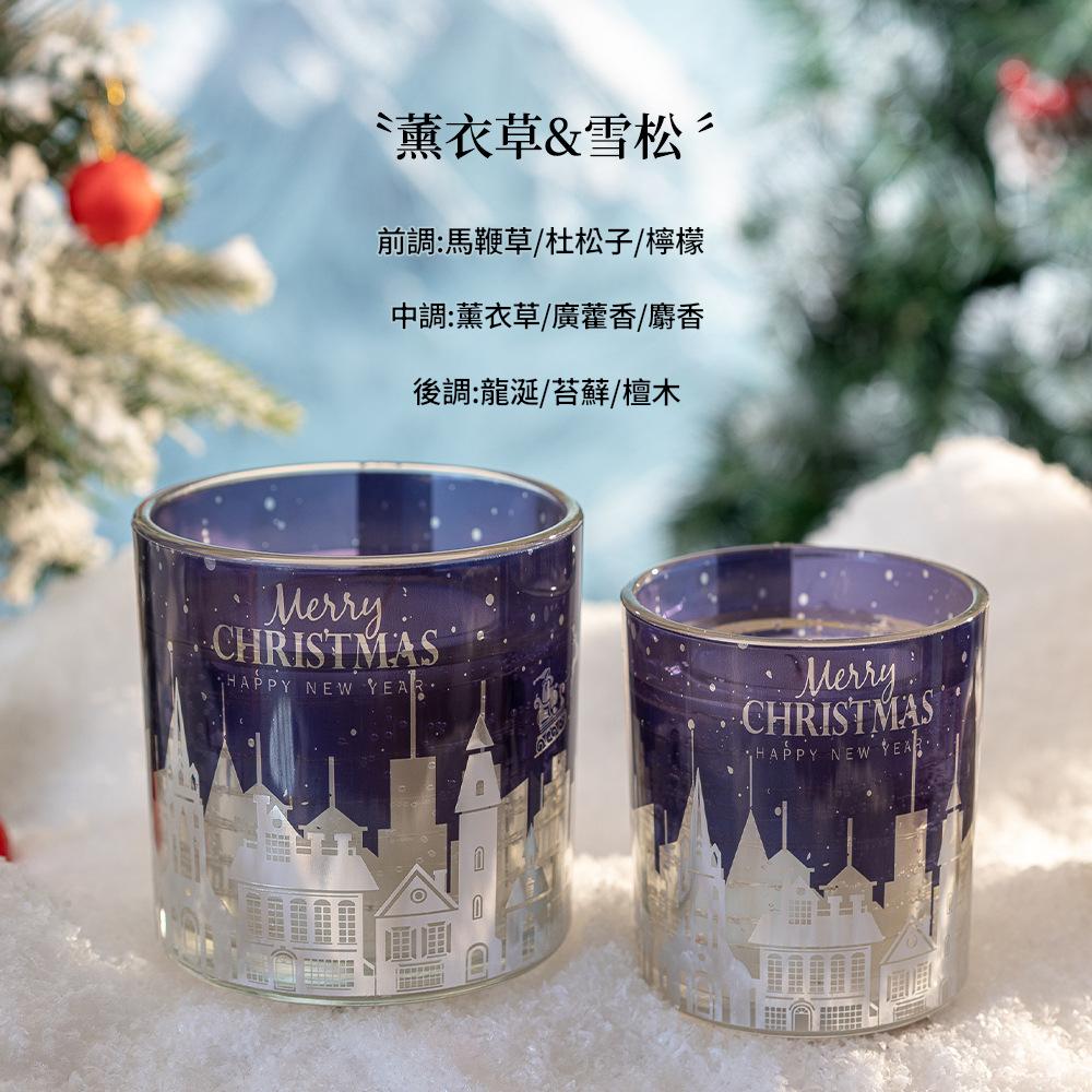 Two Christmas-themed candle holders with a snowy village design on a white surface.