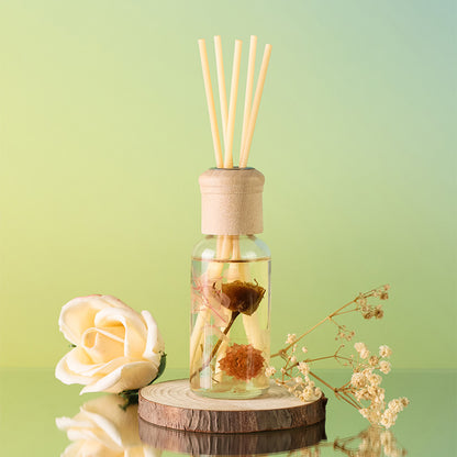 Reed diffuser with wooden sticks in a clear bottle on a green background