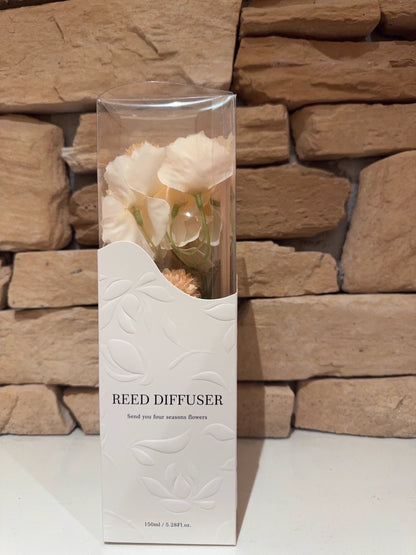 Reed diffuser with flowers and stones on a beige background