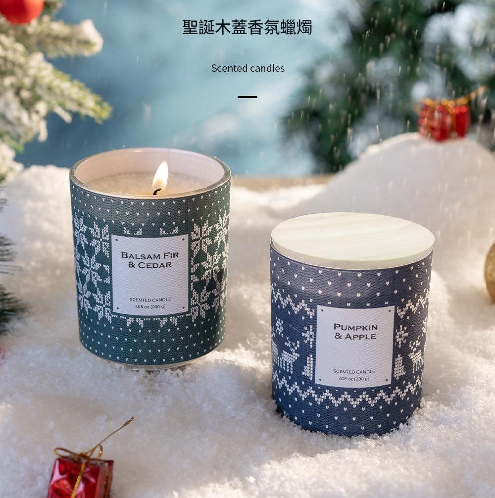 Two scented candles with festive labels on a snowy background