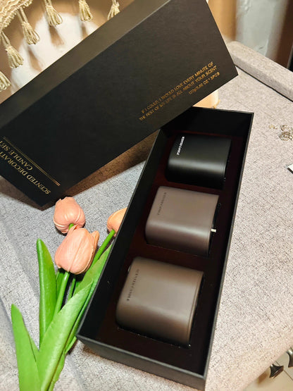 Two gray cylindrical objects in a black box with 'Ceramic Studio' branding, accompanied by pink tulips.