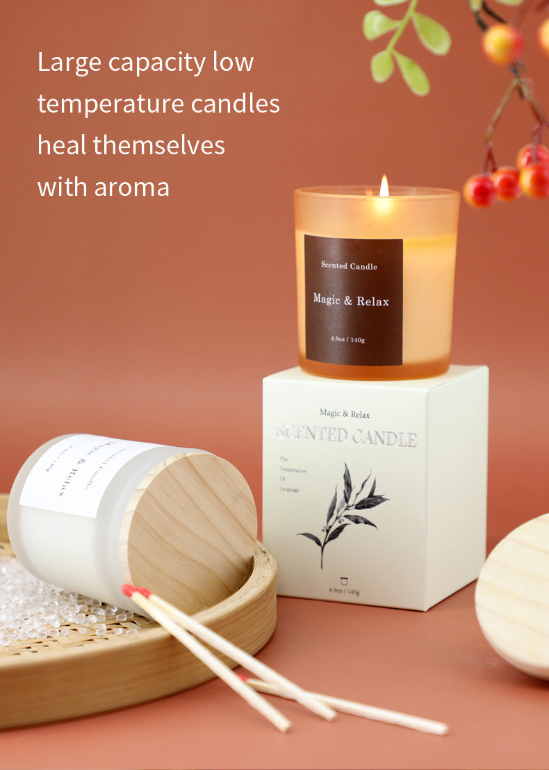 Scented candle with packaging on a wooden surface, surrounded by decorative elements.