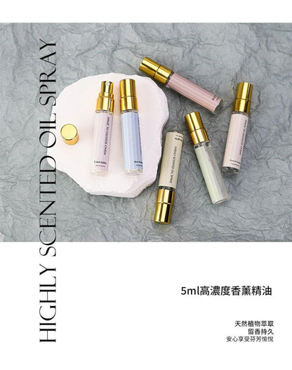 Set of small perfume bottles with gold caps on a textured gray background