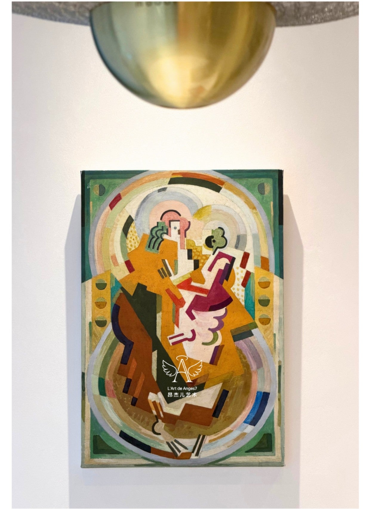 Colorful abstract painting on a white wall with a gold light fixture above.