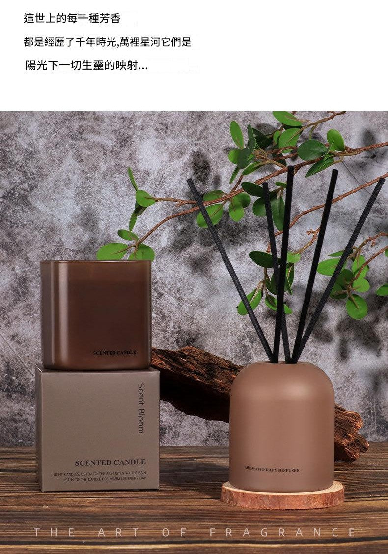 Brown candle and diffuser set with decorative elements on a wooden surface