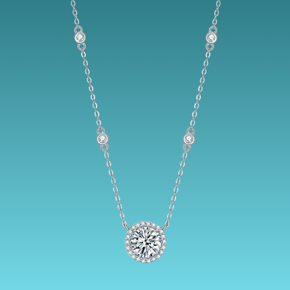 Silver necklace with a round diamond pendant on a teal background